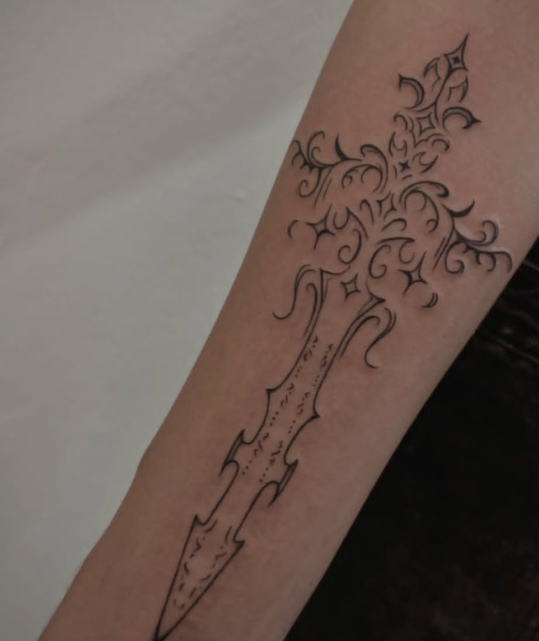 Tatuagem de adaga ornamental em traço fino no antebraço
